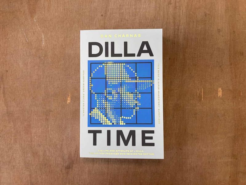 A paperback copy of Dan Charnas’s book “Dilla Time” sitting on a wooden table